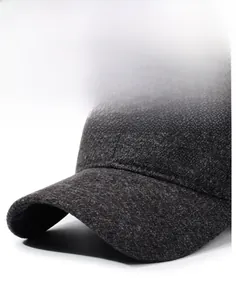 Dettaglio della visiera rigida e logo GK in metallo su cappellino invernale grigio scuro