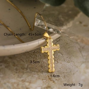 18K gold plated cross pendant necklace with sparkling zircons on a ceramic bowl