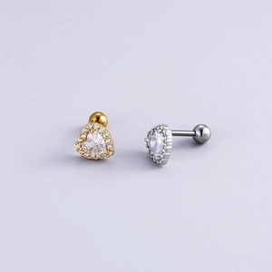 Macro shot of gold and silver heart-shaped ear studs with cubic zirconia and screw-on back