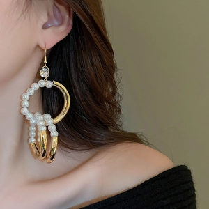Detailansicht goldener Perlenohrringe mit Zirkonia-Verzierung an einem Model