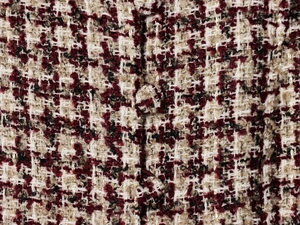Detail of tweed fabric in burgundy and cream with subtle gold metallic thread weave