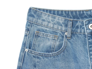 Detailansicht der High-Waist Balloon-Jeans mit Nieten und blauer Denim-Struktur im Fokus