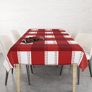 Detailed view of red and white buffalo plaid Christmas tablecloth in a home dining setting