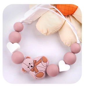 Detailed view of a pink bear silicone pacifier clip with round and heart beads