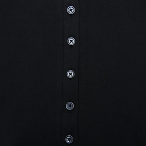 Close-up of black polo dress placket with five dark buttons and fine fabric texture