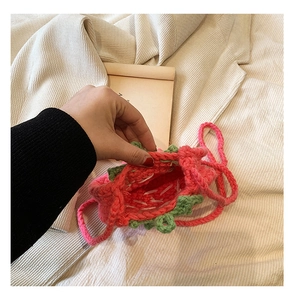 Detailansicht der handgefertigten Erdbeertasche mit Fokus auf die Strickarbeit im Inneren