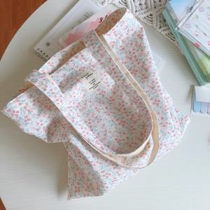 Close-up of floral cotton tote bag with vintage pattern and decorative woven label