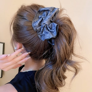 Detailed view of large dark grey fabric scrunchie with cute black bow pattern design