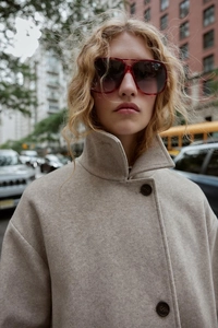 Close-up of beige wool blend coat with single-breasted design and soft texture details