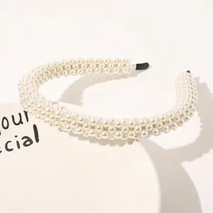 Detail of woven white pearl headband with soft anti-slip tips on a ceramic plate