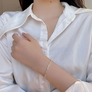 Minimalist 925 sterling silver rectangular link chain bracelet worn on a woman wrist