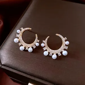 Gold-plated C-shaped earrings with crescent cubic zirconia stones and pearls