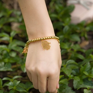 Golden stretch bead bracelet for women featuring a Hamsa Hand charm in titanium steel