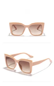 Detail view of large square cat-eye sunglasses with beige frames and gradient lenses