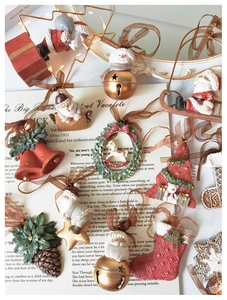 Flat lay of vintage Christmas ornaments with Santa and pinecones on a newspaper background