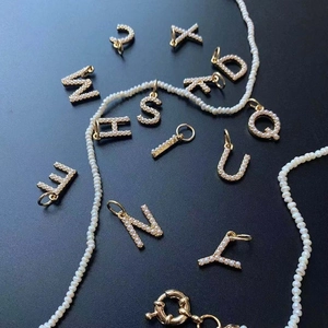 Collier de perles avec pendentifs lettres en métal doré et pavé de perles blanches