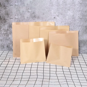Various sizes of blank kraft paper bags and envelopes displayed on a checkered cloth