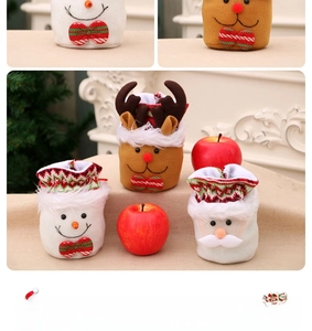 Close-up of linen Christmas gift bags with snowman, reindeer, and Santa Claus patterns