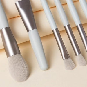 Close-up of soft white bristles and grey handles of the 8-piece mini makeup brush set