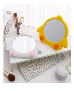 Close-up of cute cartoon chick and bear tabletop makeup mirrors on a white storage shelf