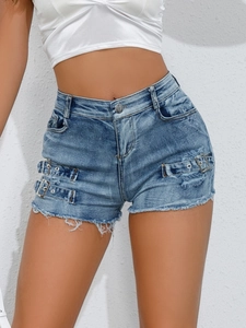 Detail of high-waisted denim shorts featuring side metal buckles and frayed raw hem design