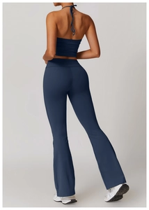 Détail du haut de yoga dos nu à bretelles et du pantalon évasé bleu foncé