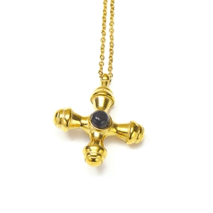 Close-up of gold cross pendant necklace featuring a polished black natural stone center