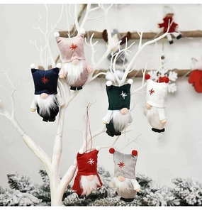 Close-up of colorful Christmas gnome ornaments hanging on white branches in 6 vivid colors