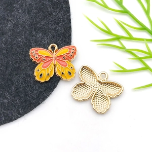 Detailed front and back view of orange enamel butterfly pendant with golden texture