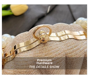 Detail of shell evening bag with champagne glitter finish and white pearl embellishments