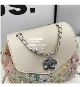 Detail of flower-shaped rotating metal lock and colorful tweed fabric with fringe