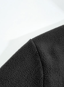 Close-up of black heavy fleece fabric texture with durable stitching on jacket edge