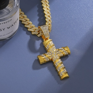Iced-out gold cross pendant with Cuban chain necklace on an elegant blue background