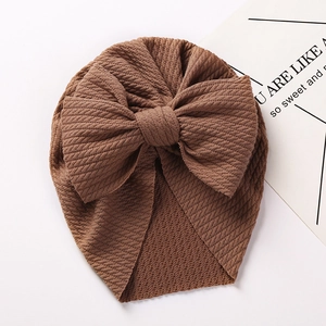 Detailed waffle texture and oversized bow on a caramel brown knit baby turban hat