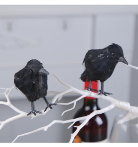 Realistic black feathered crow ornaments standing on white branches for Halloween decor