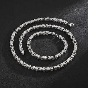 Polished silver stainless steel Byzantine chain set with lobster clasp on textured surface