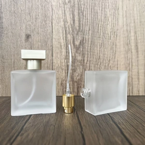 Detailed macro view of square frosted glass perfume bottle with gold atomizer components