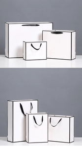 Three sizes of white gift bags with black borders and elegant black ribbon handles