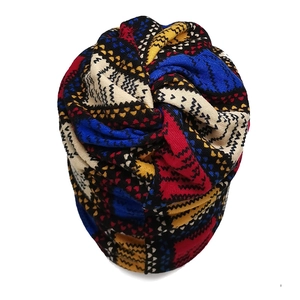 Detail of colorful geometric knit beanie with vibrant red, blue, and yellow patterns