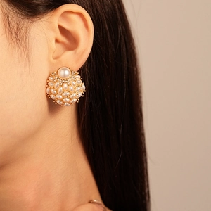 Close-up of elegant pearl cluster earrings with rhinestones worn by a model