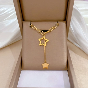 Detail of Y-shaped gold star necklace with paperclip chain and tassel drop pendant