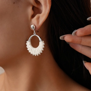 Close-up of model wearing retro geometric round earrings with white leather weaving