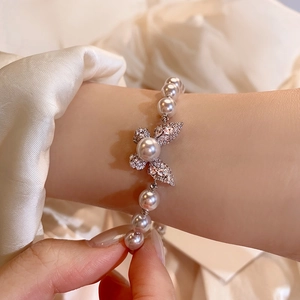 Dettaglio di un elegante bracciale di perle a farfalla in oro rosa con squisita fattura