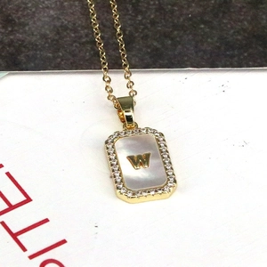 Detail of 18K gold plated shell pendant with inlaid letter W and zircon border