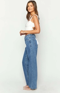 Detail of light blue high waist wide leg jeans featuring a back pocket white bow ribbon