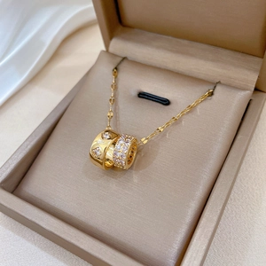 Detail of gold titanium steel double ring necklace with cubic zirconia in a jewelry box