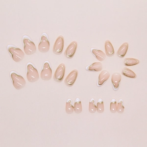 Détail de 24 faux ongles rose nude avec pointes French blanches et lignes dorées ondulées