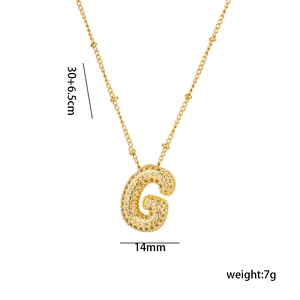 Macro detail of 18K gold plated letter G pendant with micro-pave cubic zirconia