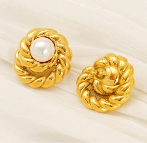 Detailed macro view of retro 18K gold-plated twisted pearl stud earrings on white silk