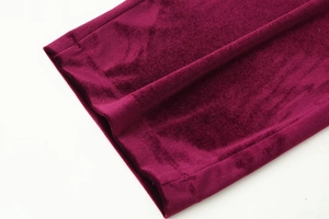 Detailed close-up showing the smooth stitching on the burgundy velvet fabric hemline